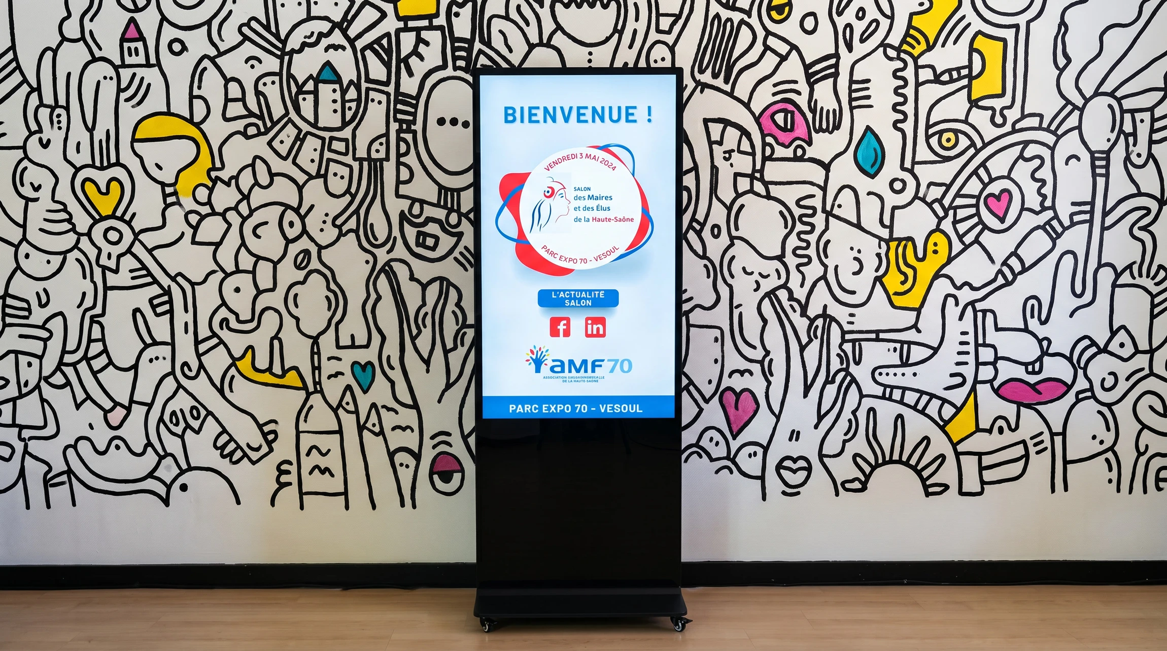 Photographie d'un écran LED haute résolution installé dans le mur ou sur un support d'une réception d'entreprise moderne, affichant du contenu dynamique professionnel (graphiques, textes, images), avec un environnement d'accueil épuré et contemporain en arrière-plan légèrement flou, montrant l'intégration réelle de la technologie dans un contexte professionnel.