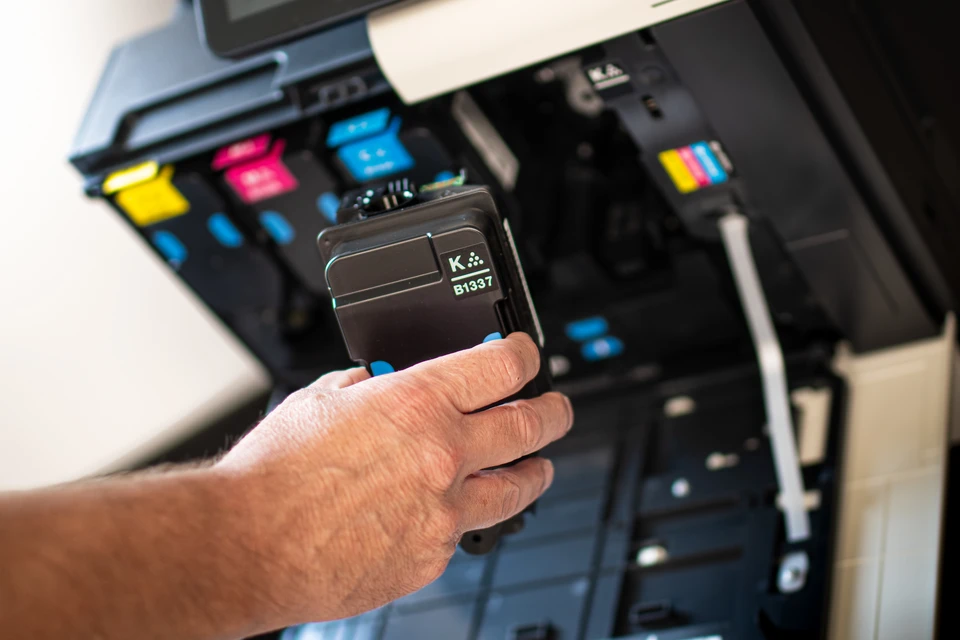 Bureau moderne avec imprimante multifonction professionnelle ouverte, révélant vitre de numérisation et bac d'alimentation papier