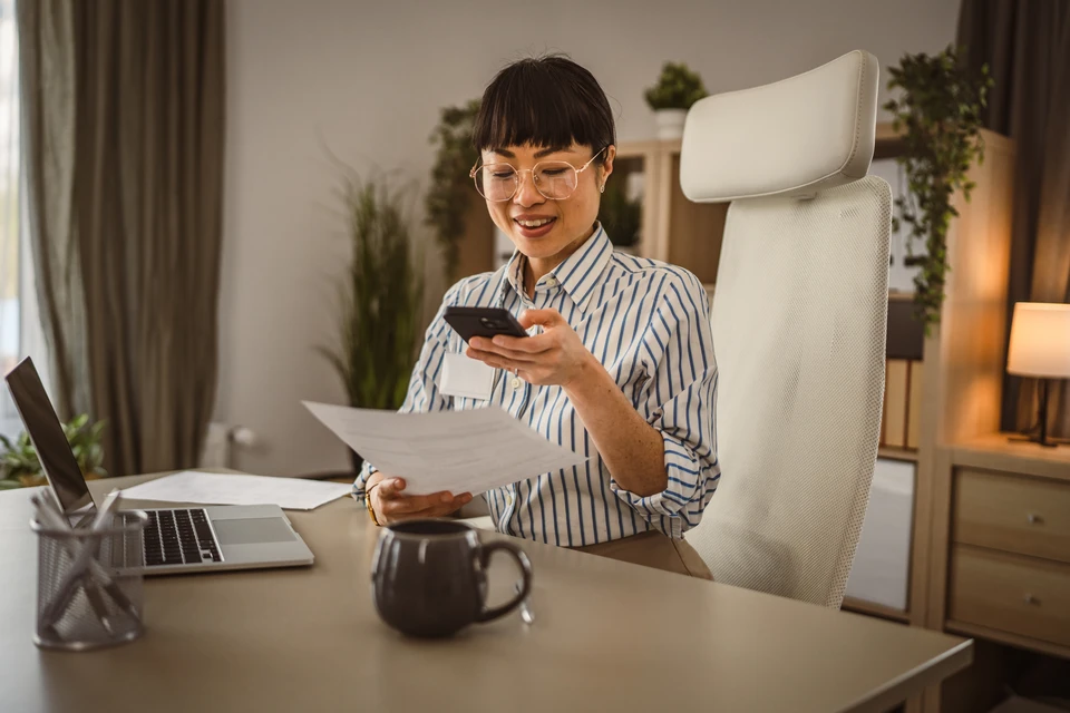 Trois professionnels en réunion collaborative dans un bureau moderne, consultant ensemble une tablette numérique