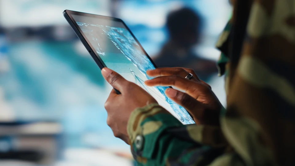 Homme en costume sombre travaillant sur documents papier avec stylo, dans un environnement professionnel intérieur