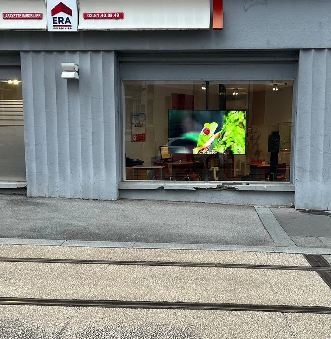 Devanture de magasin "YELLOWKORNER" avec vitrine éclairée présentant des photographies d'art encadrées