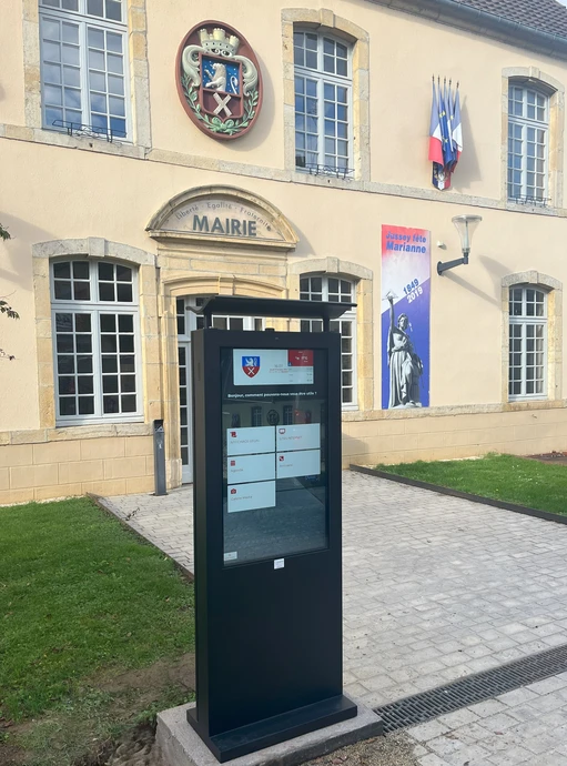 Scène urbaine avec panneau publicitaire jaune affichant "ADVERTISING" au centre d'une place pavée, entouré de bâtiments modernes en verre et béton