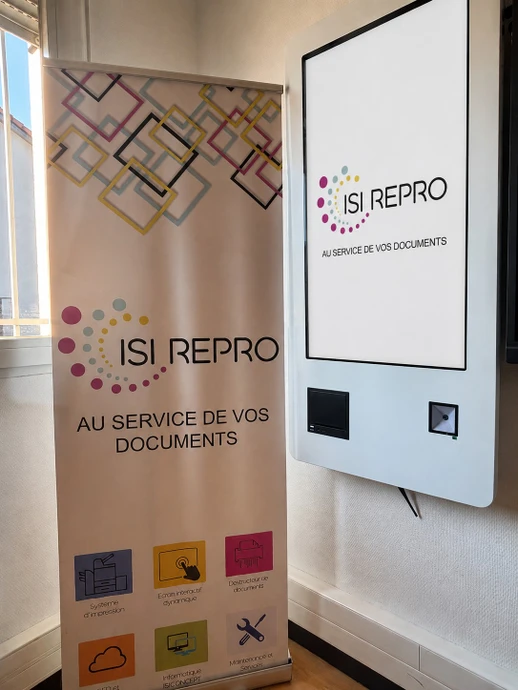 Photographie en environnement intérieur professionnel montrant un grand écran interactif moderne installé au mur ou sur pied dans une salle de réunion. L'écran affiche une interface collaborative ou un contenu de présentation. Deux à trois professionnels en tenue de travail sont présents dans la pièce, interagissant avec l'écran ou se tenant à proximité, démontrant l'utilisation collaborative et la modernité de l'équipement. Éclairage naturel ou professionnel, décoration intérieure contemporaine et mobilier de bureau moderne.
